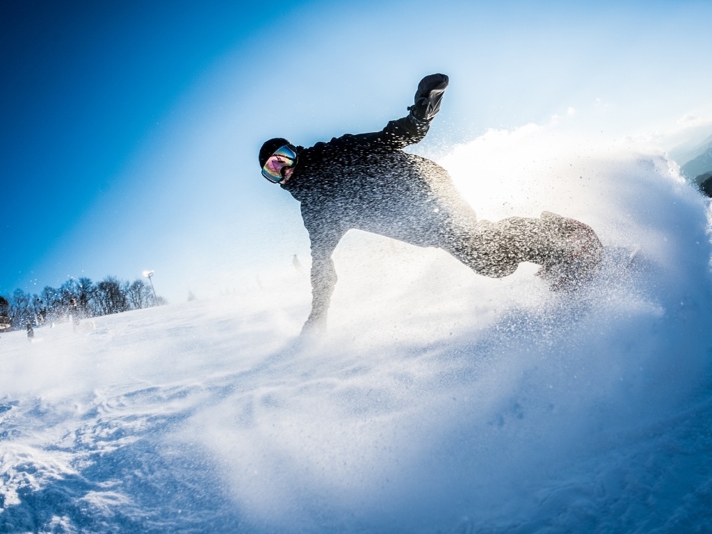 運営するスキー場の広大なゲレンデを滑走するスノーボーダー